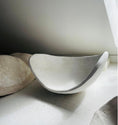 Bild in Galerie-Betrachter laden, Das Bild zeigt eine Belly Bowl aus einem Babybauch Gipsabdruck während des Trocknungs- und Veredelungsprozesses auf dem Arbeitstisch im Atelier. Die handgefertigte Bauchschale wird Schritt für Schritt verspachtelt, grundiert, geschliffen und lackiert. Jeder Babybauch und jeder daraus entstehende Gipsabdruck ist ein einzigartiges Unikat und wird individuell in liebevoller Handarbeit angefertigt und vere - Atelier Body - pArts