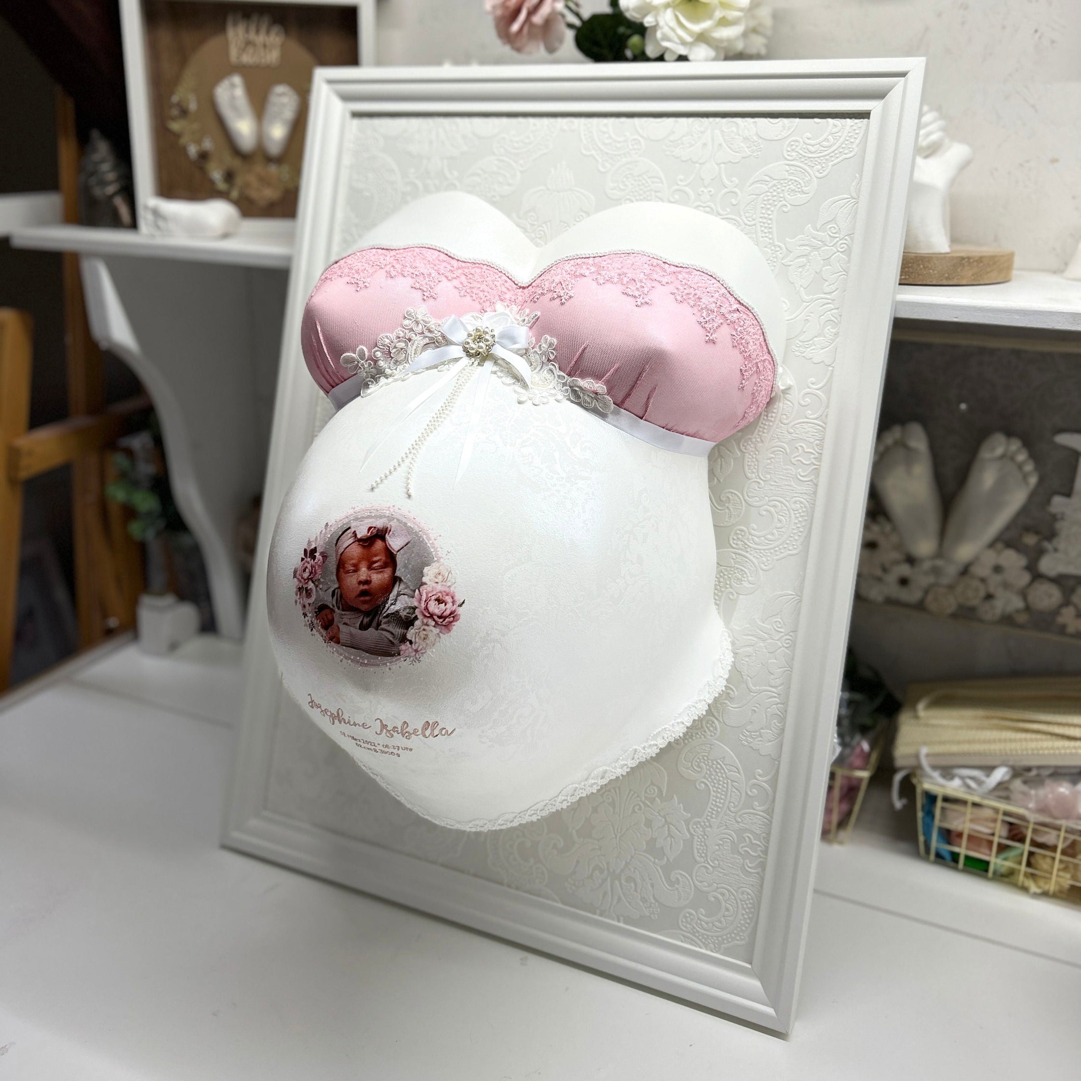 Veredelter Babybauch-Gipsabdruck BH-Design Eleganz, individuell lackiert und mit Babyfoto gestaltet, im Rahmen mit Beleuchtung – professioneller Service im Atelier Bodyparts, Erfurt.
