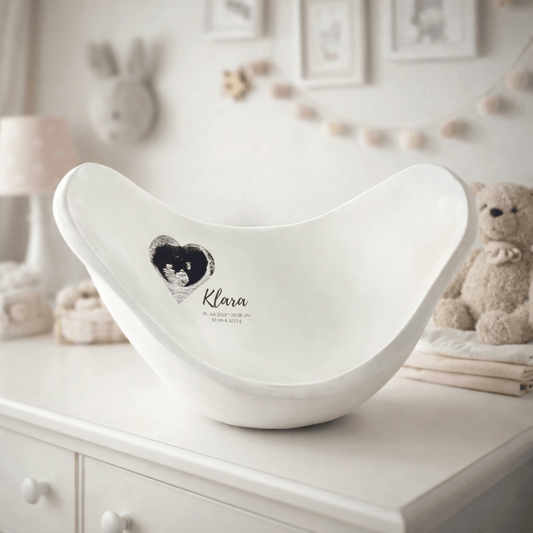 Elegante weiße Belly Bowl aus einem Babybauch Gipsabdruck, liebevoll als Bauchschale gestaltet und von innen personalisiert. Die schlichte Gestaltung zeigt ein kleines Herz mit Ultraschallbild sowie den Geburtsdaten von Klara. Die handgefertigte Bauchschale wurde professionell verspachtelt, grundiert und lackiert und dient als modernes Erinnerungsstück an Schwangerschaft und Geburt. - Atelier Body - pArts